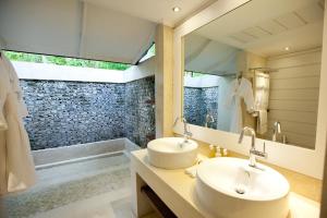 a bathroom with two sinks and a bath tub at Diamonds Athuruga Maldives Resort & Spa in Athuruga Island