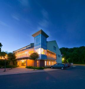 a building with a car parked in front of it at Berghotel Sammüller in Neumarkt in der Oberpfalz