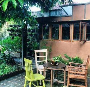 patio z 2 krzesłami, stołem i krzesłami w obiekcie Rumah Turi Eco Boutique Hotel w mieście Surakarta