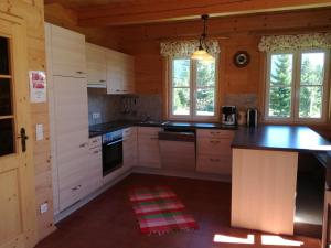 a kitchen with white cabinets and black counter tops at Stoffis Hütten in Tauplitz