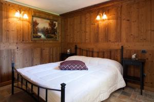コー​​ニュにあるAppartamento con prato privato e BBQのウッドパネルの壁とベッドが備わるベッドルーム1室