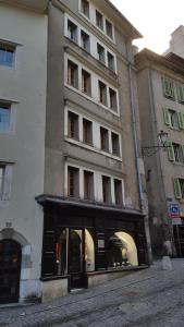 un grand bâtiment avec un magasin devant lui dans l'établissement Boel 4 Studio, à Genève