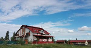 una casa con techo rojo en la parte superior de un campo en Kisdunapart 510, en Taksony