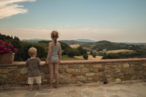 een jonge jongen en een meisje staan op een stenen muur bij Monti 1824 - Apartments & Cottages in Casole dʼElsa