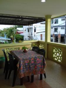 a table and chairs on a balcony with a view at Mai Chenang Guesthouse in Pantai Cenang