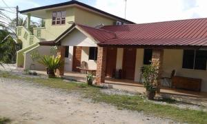 a small house with a red roof at Mai Chenang Guesthouse in Pantai Cenang +6 photos