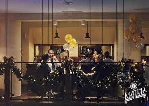 a group of people sitting at a table with balloons at Hotel Silvia Gold Gliwice in Gliwice
