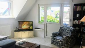 a living room with a chair and a television at Mach mal Pause bei Geni & Bernd in Kleineichen