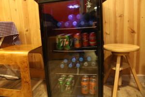 a refrigerator filled with sodas and cans of soda at Buba House - Women Only Hostel in Barcelona