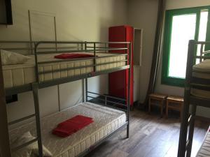 バルセロナにあるブーバ ハウスの二段ベッド3台と赤い冷蔵庫のある部屋