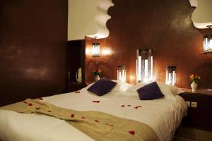 Un dormitorio con una gran cama blanca con rosas rojas. en Riad Granvilier, en Marrakech