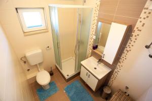 a bathroom with a toilet and a sink and a shower at Apartment Pa Ve in Murter +23 photos
