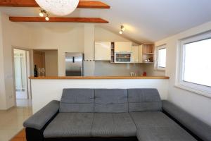 a living room with a couch and a kitchen at Apartment Pa Ve in Murter