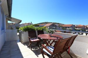 a patio with a table and chairs on a balcony at Apartment Pa Ve in Murter