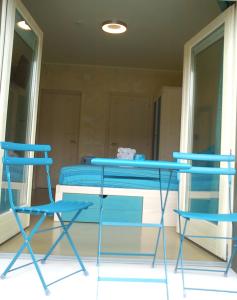 duas cadeiras azuis e uma mesa num quarto em Bikapi em Garda
