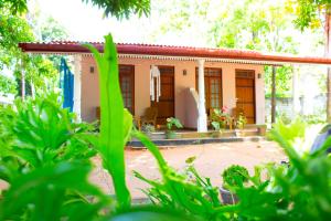 una pequeña casa con techo rojo en Sigiri Leisure Holiday Home, en Sigiriya
