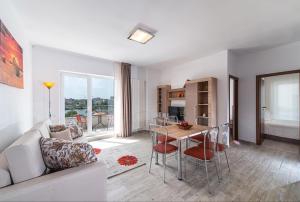 a living room with a couch and a table with chairs at Residence iL Lago in Cluj-Napoca