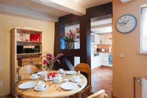 a dining room with a table and a clock on the wall at Das Ferienhaus in Quedlinburg