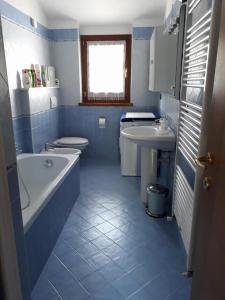 a blue and white bathroom with a tub and a sink at B&B Edelweiss in Oulx