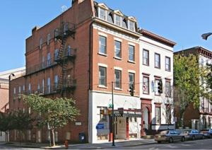 ein Backsteingebäude auf einer Stadtstraße mit vor der Tür geparkt in der Unterkunft Midtown Inn in Baltimore