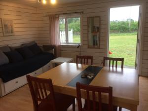 a living room with a table and a couch at Ölands Yoga Studio & Islandshästar, Stugor & Rum in Mörbylånga