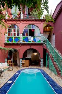 a house with a swimming pool in front of a building at Riad Wardate Rita in Marrakech