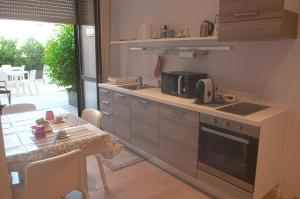 a kitchen with a table and a stove top oven at Four Rooms Guesthouse in Oristano