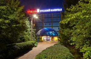 a building with a neon sign in front of it at Russky Capital Hotel in Nizhny Novgorod