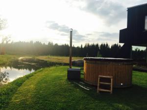 uma banheira de madeira ao lado de uma massa de água em Kõveri Holiday Center em Kõveri