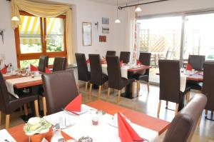 a dining room with tables and chairs with red napkins at Pension Bella Vista in Bochum