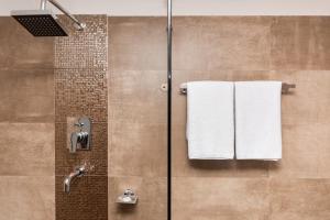 una doccia con asciugamani bianchi in bagno di The Museum a Kathmandu