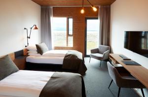 米湖Fosshotel Mývatn的有两张床和一台电视的酒店房间