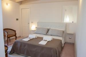 sypialnia z dużym łóżkiem z dwoma ręcznikami w obiekcie Riz Guest House w mieście Montesano Salentino