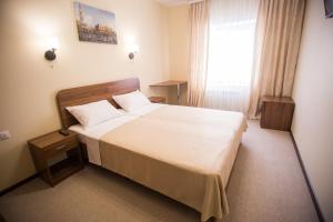 a bedroom with a large bed and a window at Hotel Zolotoi Shar in Tolyatti
