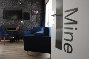 ein Wohnzimmer mit einem blauen Sofa und einem TV in der Unterkunft Les Béthunoises Béthune Centre - Studios design in Béthune