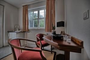 a room with a desk and chairs and a window at Hotel Restaurant Tonino in Bad Bentheim