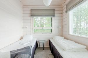 two beds in a small room with a window at Villa Jolla in Padasjoki