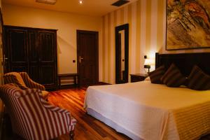 1 dormitorio con 1 cama y 2 sillas en Hotel Vinícola Real-200 Monges, en Albelda de Iregua