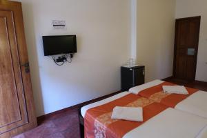 a hotel room with a bed and a television at Hotel Celi in Calangute