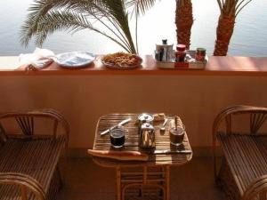 a table with a tea kettle on it with two chairs at villa al diwan luxor in Luxor