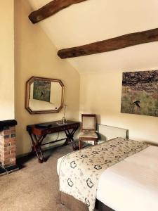 1 dormitorio con cama, espejo y escritorio en Slaters Country Inn en Whitmore