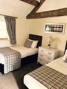 a bedroom with two beds and a dresser and a window at Slaters Country Inn in Whitmore