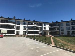 a parking lot in front of a large building at Apartment NM Bjelašnica in Bjelašnica