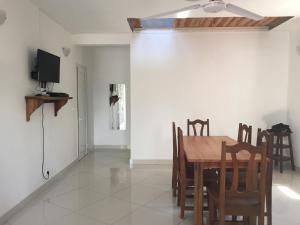 a dining room with a table and chairs and a tv at Villa Violette in Ambatoloaka