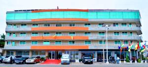um edifício com carros estacionados em frente em Nobila Airport Hotel em Cotonou