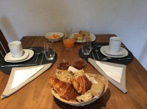 stół z talerzem chleba i szklanki soku pomarańczowego w obiekcie Domaine de Tréouzien w mieście Plouhinec