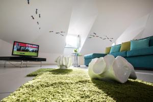 a living room with a green couch and a tv at Fruit Flats by AMALFIVACATION in Minori