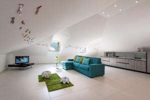 a living room with a blue couch and a tv at Fruit Flats by AMALFIVACATION in Minori