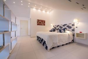 a white bedroom with a bed and a television at Fruit Flats by AMALFIVACATION in Minori