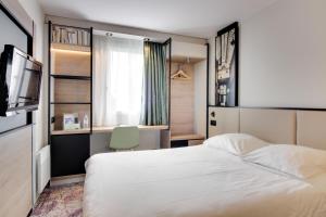 Le Relecq-KerhuonにあるBrit Hotel Brest Le Relecq Kerhuonのベッドとテレビが備わるホテルルームです。